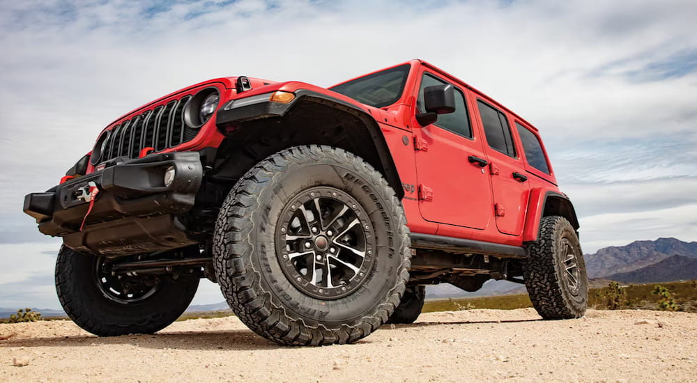 Low view of a red 2026 Jeep Wrangler parked off-road.