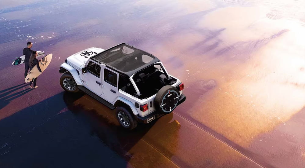 White 2026 Jeep Wrangler driving off-road.