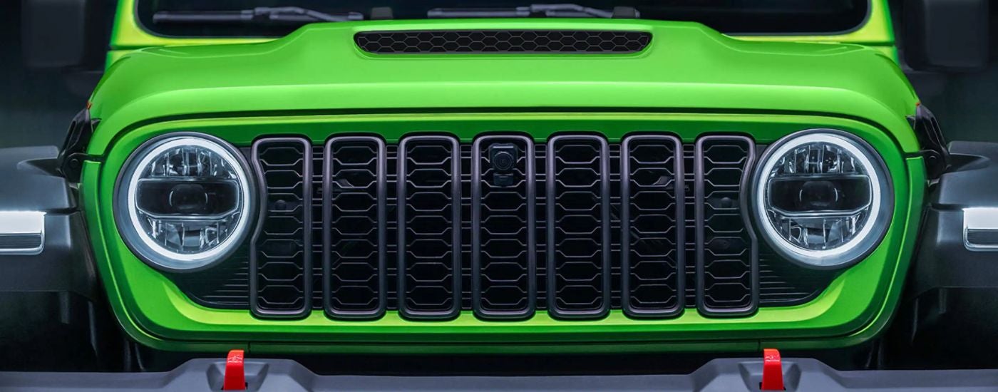 The front grille of a lime green Jeep Wrangler Rubicon.