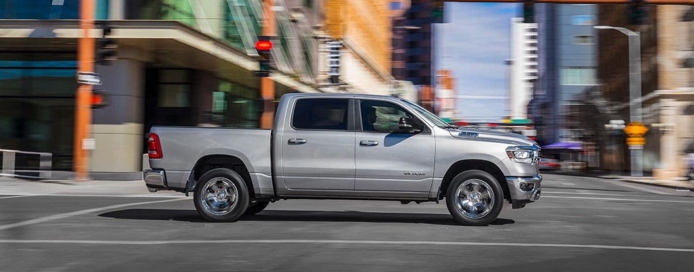 Silver 2019 Ram 1500 driving through a city intersection
