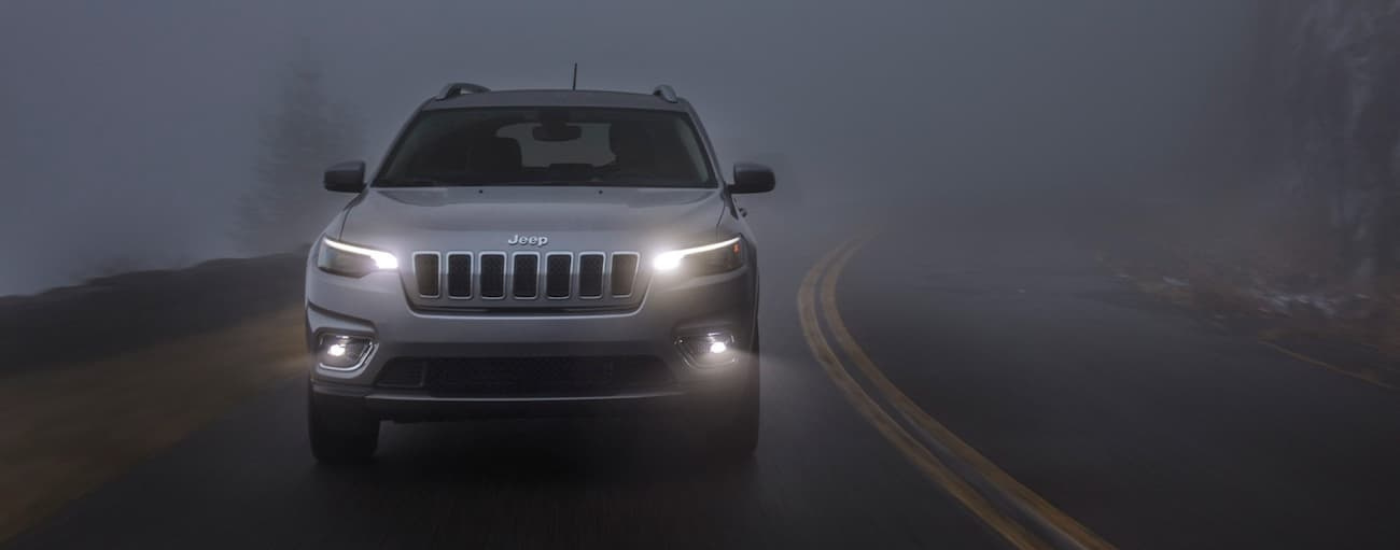Silver 2020 Jeep Cherokee driving to see used Jeeps for sale near Howell