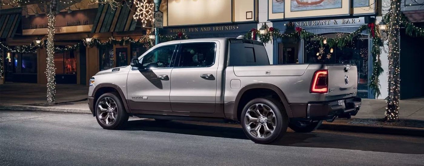 Rear of a white 2020 Ram 1500 parked by a curb.