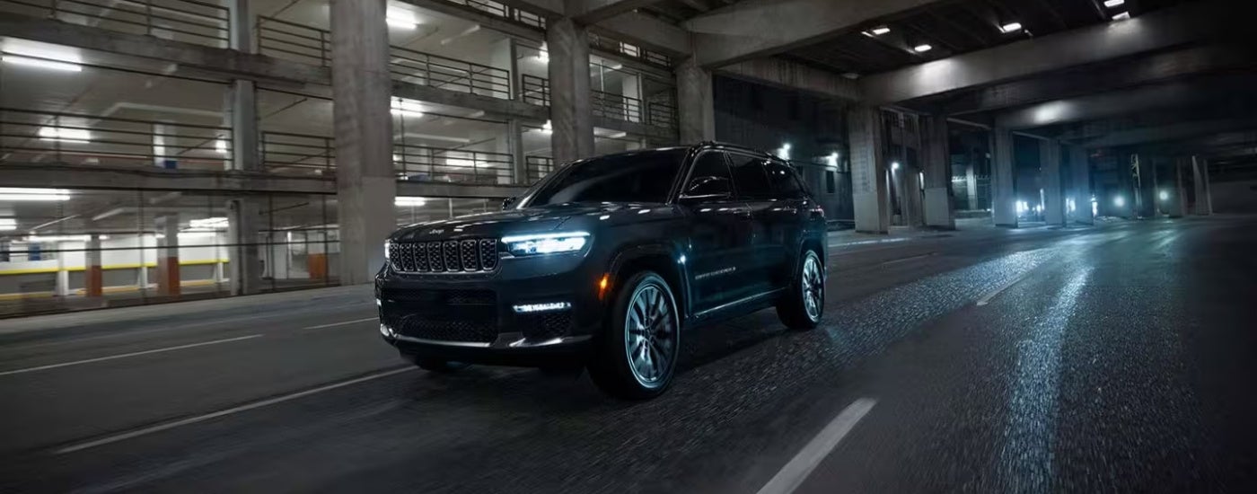 Black 2025 Jeep Grand Cherokee driving at night