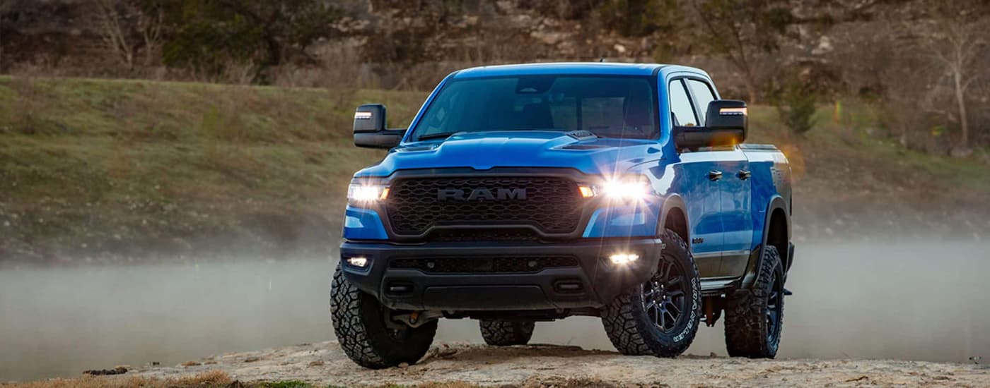 Blue 2026 Ram 1500 driving off-road.