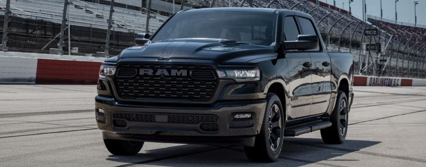 Black 2026 Ram 1500 Black Express driving on a racetrack.