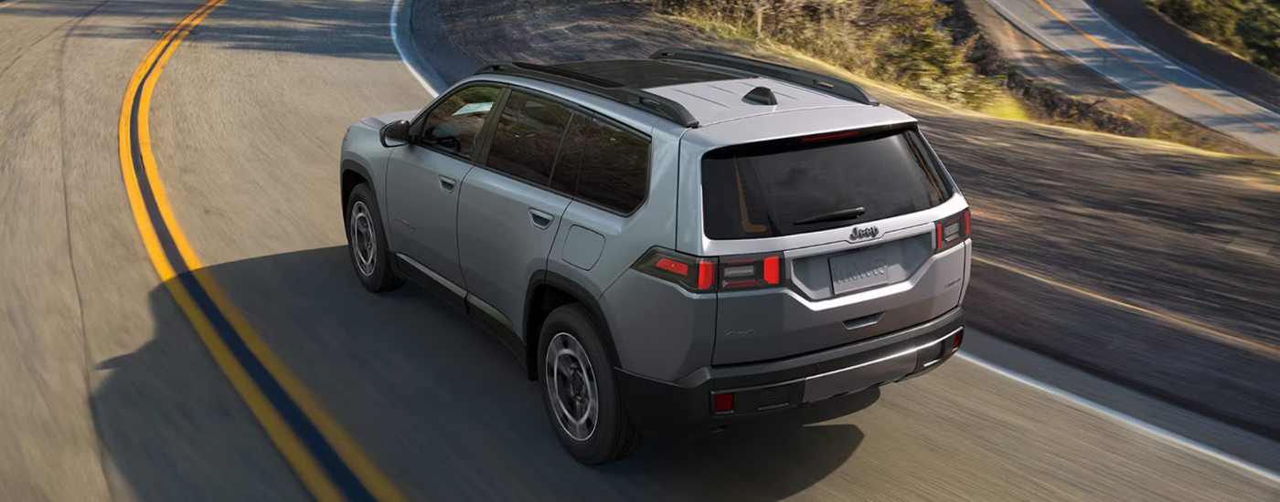Silver 2026 Jeep Cherokee rounding a corner
