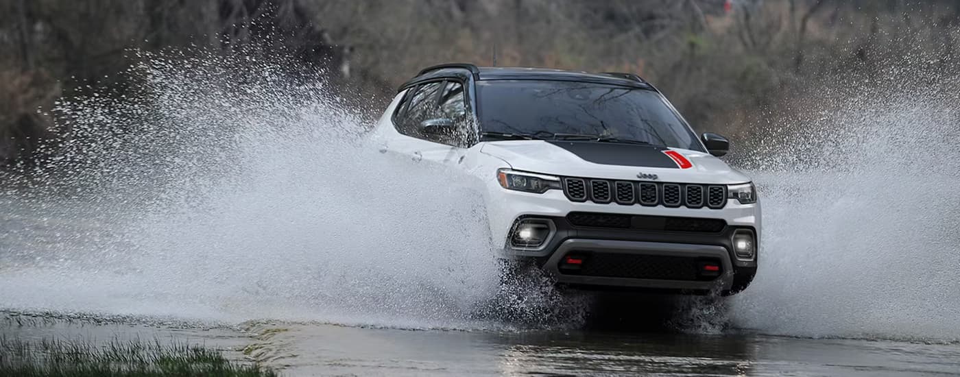 White 2026 Jeep Compass off-roading through a river