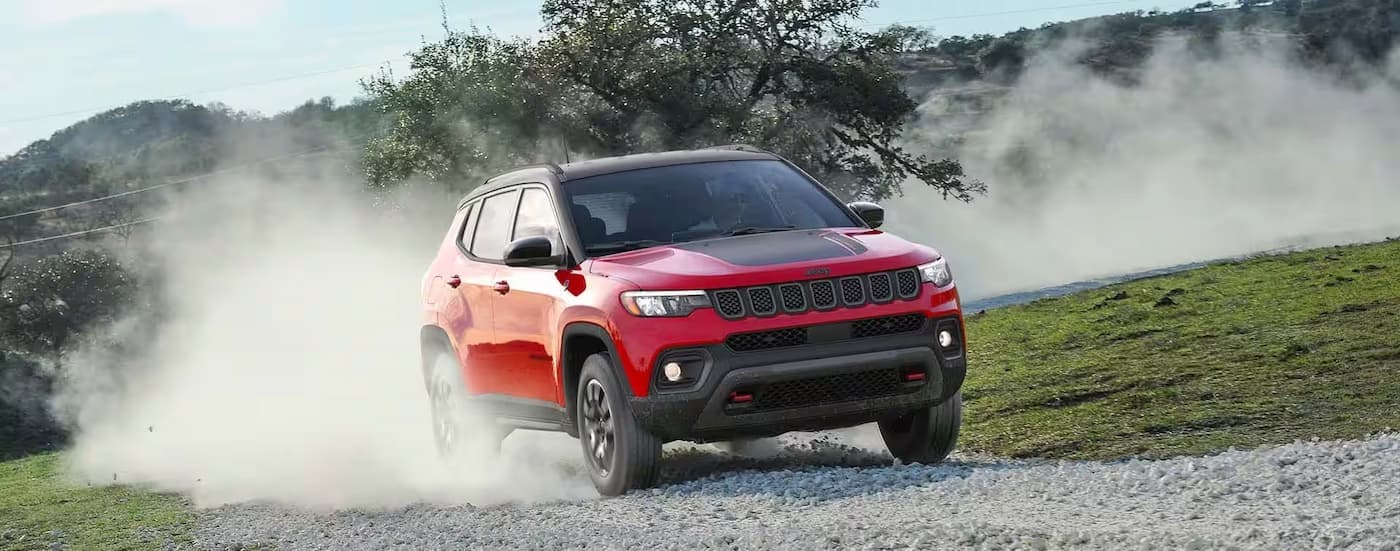 A red 2026 Jeep Compass off-roading.