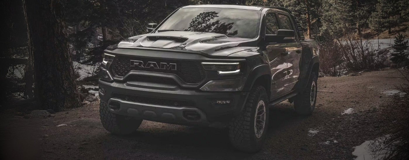 A grey 2023 Ram 1500 TRX driving to a Ram dealer.
