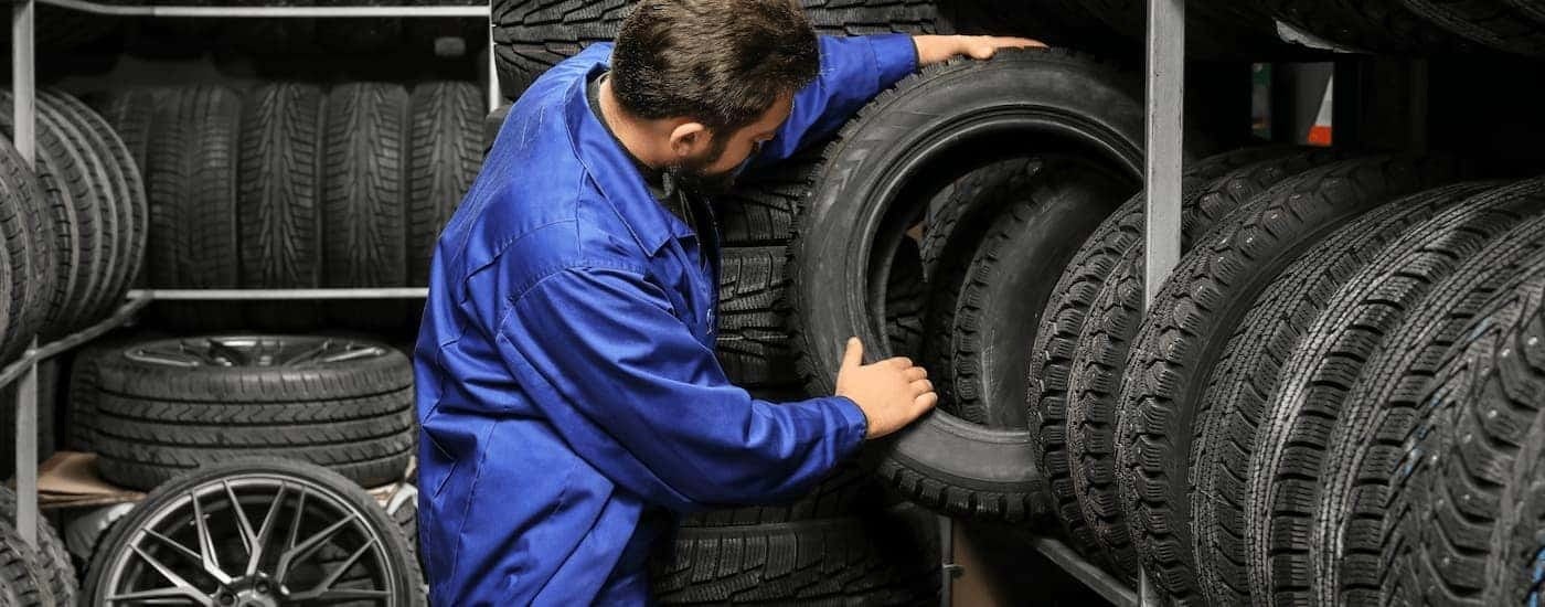 Mechanic pulling a tire off of a rack at a tire shop